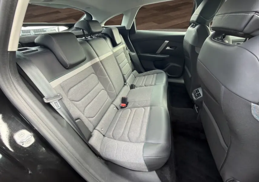 Vue intérieure côté arrière gauche de la banquette arrière bicolore gris et noir de la Citroën C4 noire 2023.