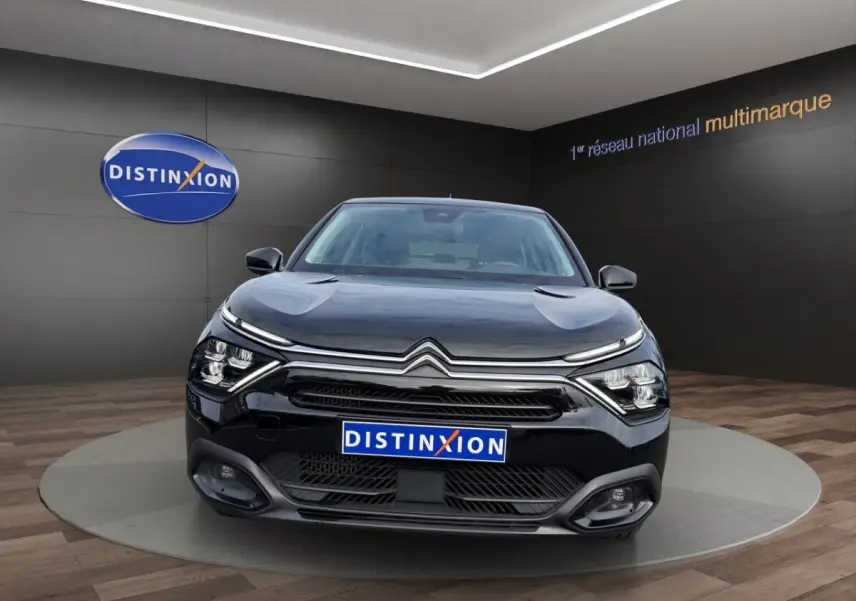 Citroën C4 noir vue de face dans un showroom avec calandre chromée et phares LED distinctifs.