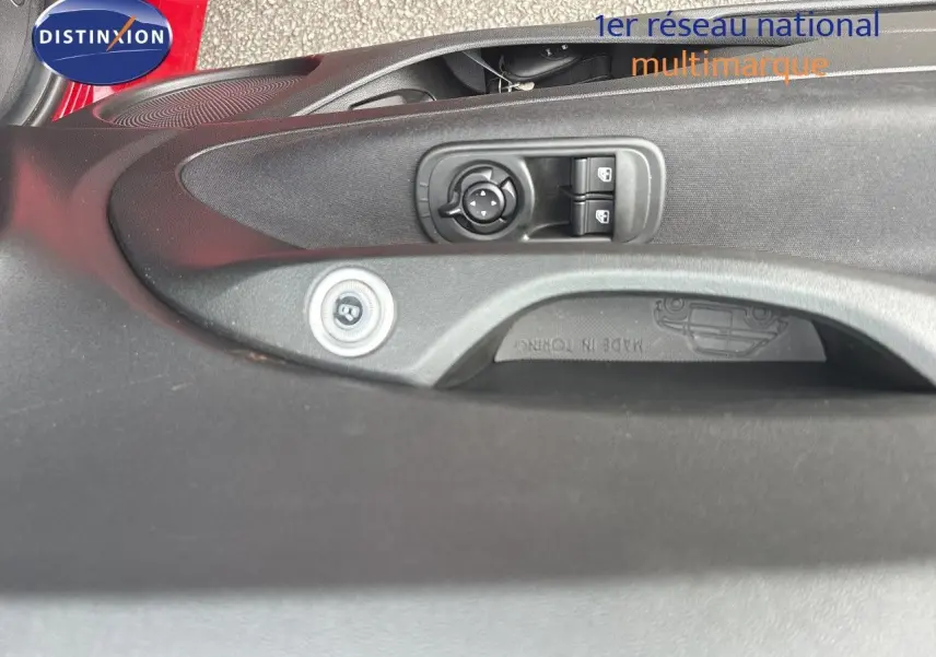 Détail de la commande des rétroviseurs et des vitres sur la porte côté conducteur d'une FIAT 500e rouge 2024.