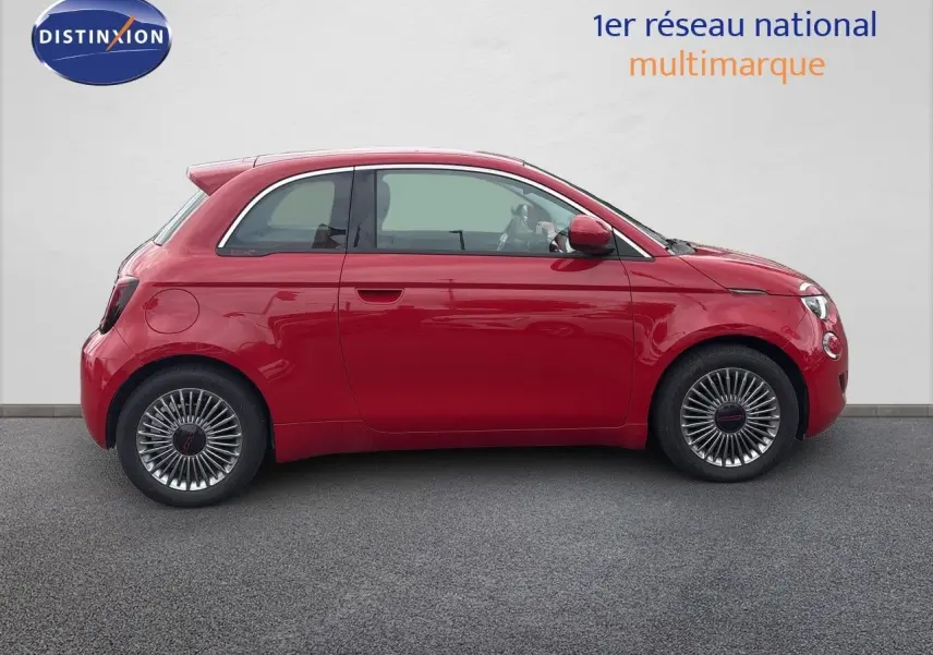 Profil droit d'une FIAT 500e rouge 2024 avec jantes classiques et lignes compactes caractéristiques.