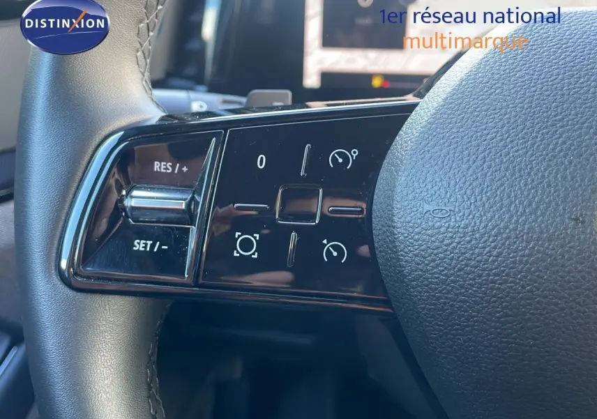 Gros plan sur les commandes à gauche du volant du Renault Austral 2023, finition hybride, avec boutons de régulateur de vitesse.