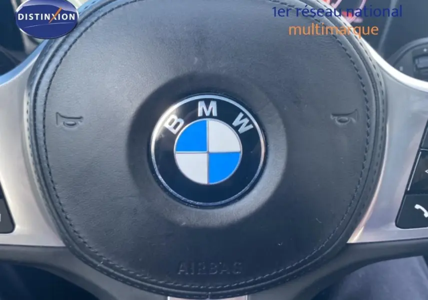 Gros plan sur le volant sport noir avec logo BMW au centre dans l’habitacle d’une Série 3 G20.