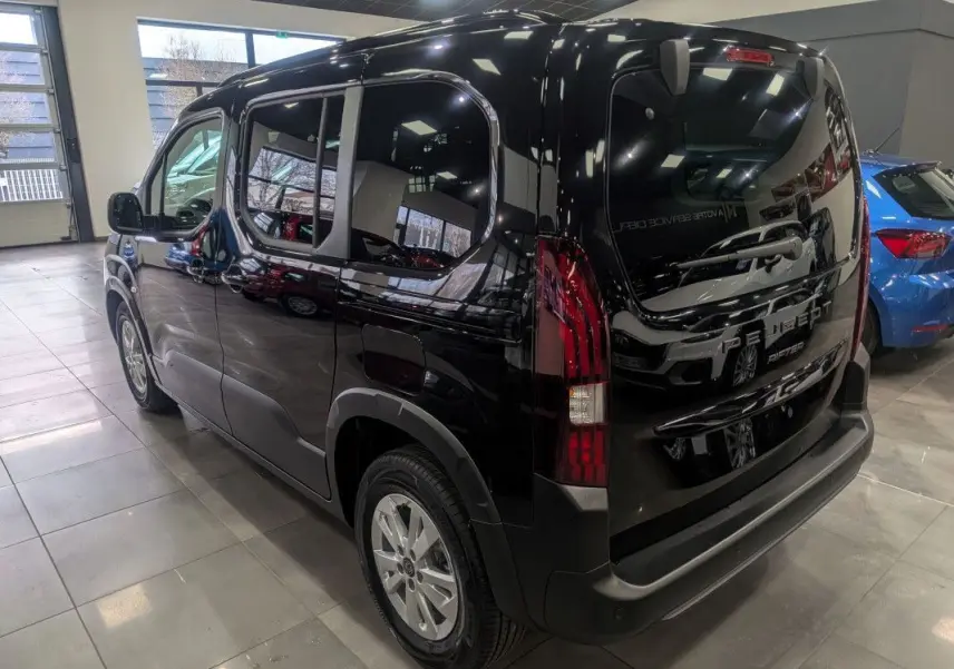 Vue 3/4 arrière droite d’un Peugeot Rifter Allure 2026 noir Perla Nera avec feux arrière LED et jantes alliage.