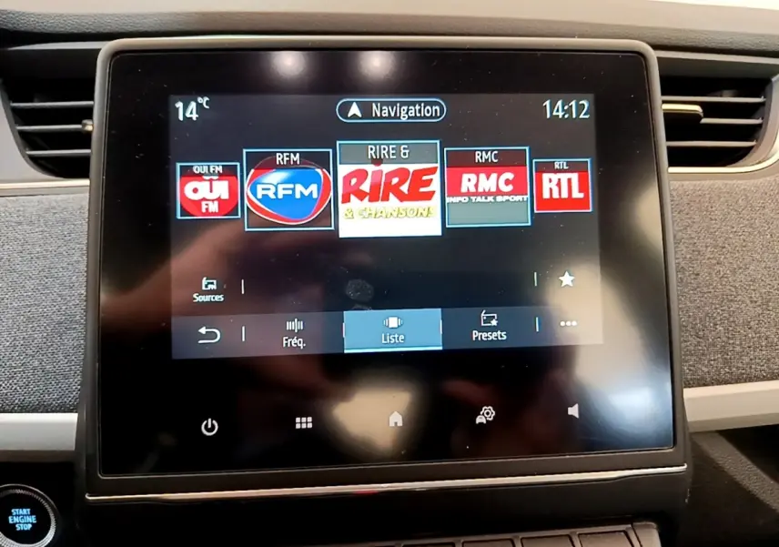 Écran tactile central de la Renault ZOE gris clair 2022 montrant les stations radio avec bouton démarrage visible.