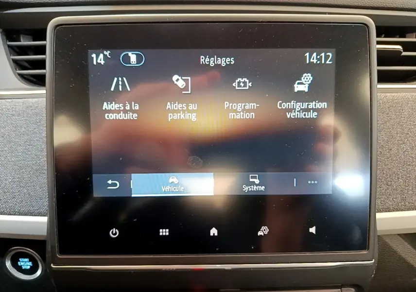 Écran tactile central de la Renault ZOE gris clair affichant le menu réglages avec options d’aides à la conduite et parking.