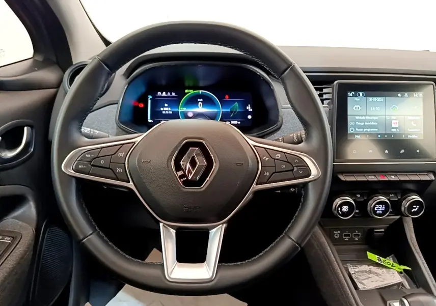 Vue intérieure centrée sur le volant noir et le tableau de bord numérique de la Renault ZOE gris clair MY22.