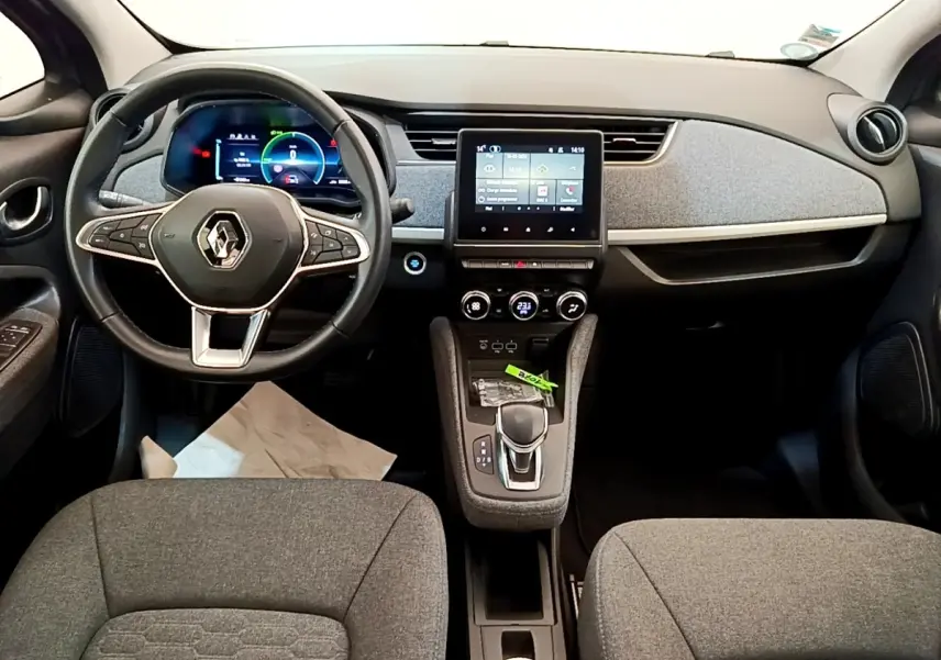 Vue intérieure avant de la Renault ZOE gris clair, avec tableau de bord numérique et écran tactile central.