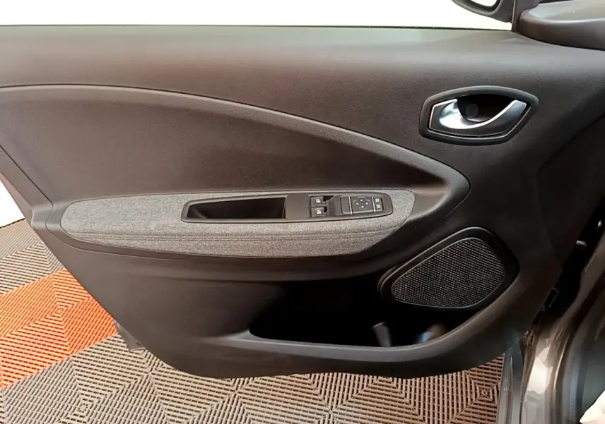 Vue rapprochée de la porte avant gauche gris clair de la Renault ZOE evolution R110 avec commandes électriques et haut-parleur intégré.