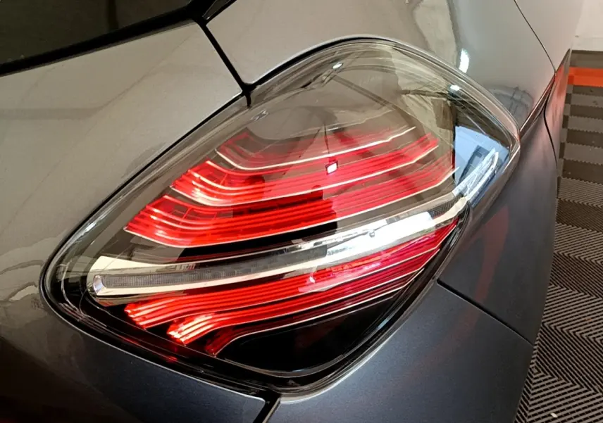 Gros plan sur le feu arrière droit rouge et blanc d'une Renault ZOE gris clair Evolution R110 2022.