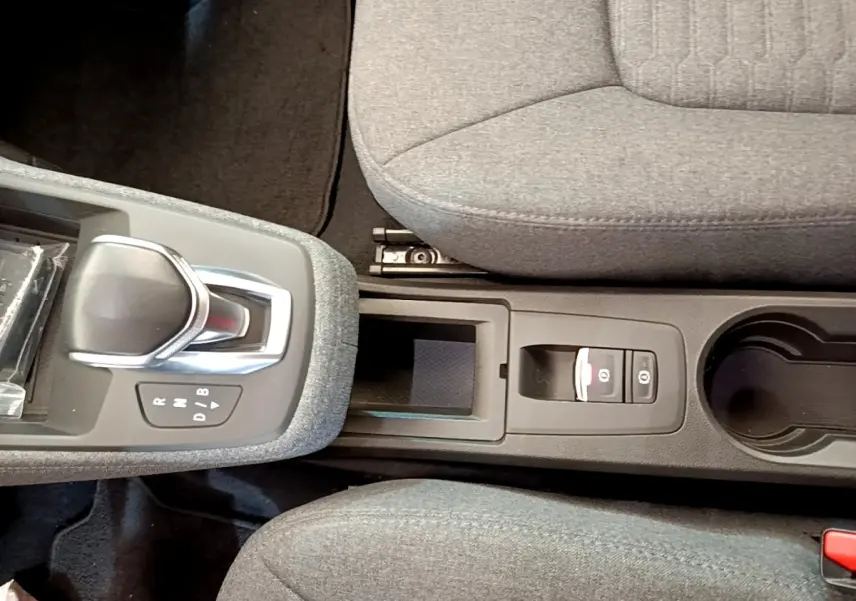 Vue plongeante sur la console centrale grise de la Renault ZOE evolution R110 avec levier de vitesse automatique et frein à main électrique.