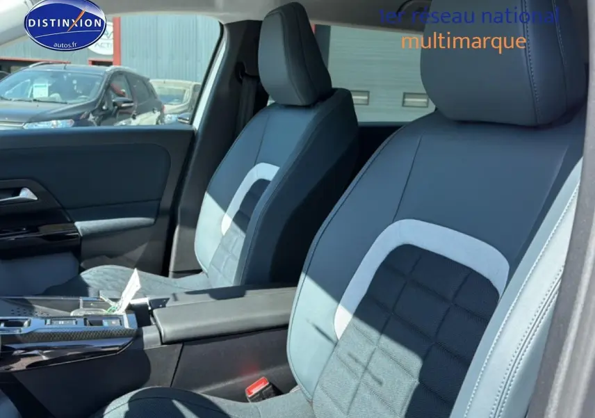 Vue intérieure côté droit montrant les sièges avant gris et noirs du Citroën C5 Aircross hybride 2026 avec accoudoir central.