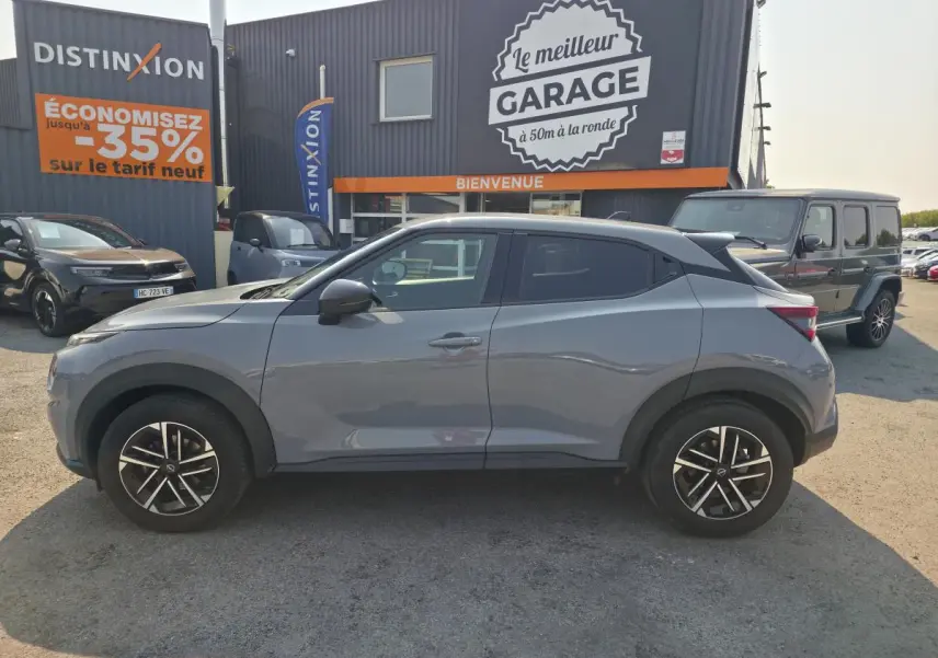Nissan Juke gris métallisé vue de profil côté gauche, avec jantes alliage 17 pouces et vitres teintées.