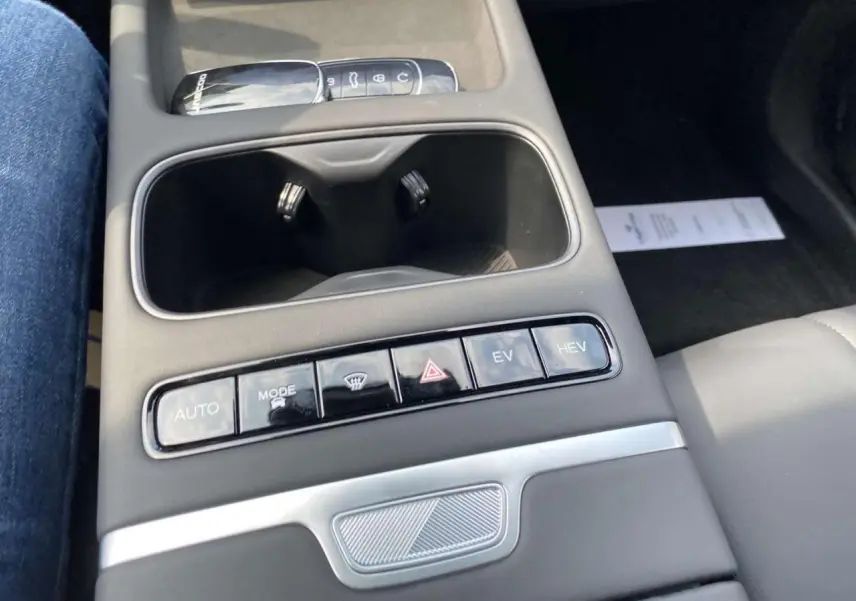 Vue rapprochée de la console centrale du JAECOO J7 2026, avec boutons de mode de conduite et porte-gobelets noirs.