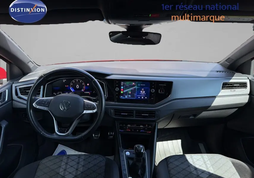 Vue intérieure avant du Volkswagen Polo 1.0 TSI 95 R-Line 2023, avec tableau de bord numérique et levier de vitesse manuel.