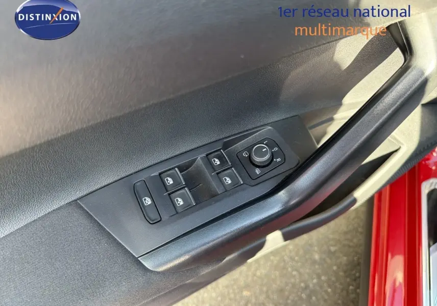 Détail des commandes des vitres et rétroviseurs sur la porte avant gauche d’une Volkswagen Polo rouge Roi 2023.