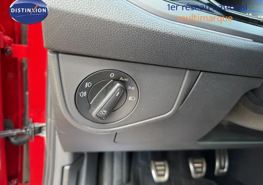 Détail du bouton de commande des phares sur le tableau de bord côté gauche d’une Volkswagen Polo rouge Roi 2023.