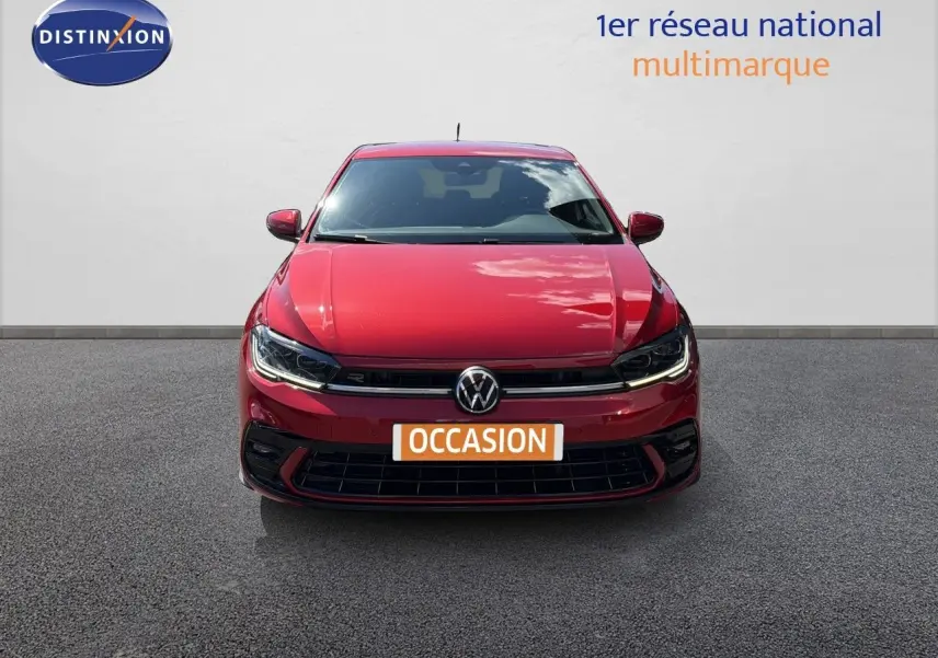Vue frontale d'une Volkswagen Polo 1.0 TSI 95 R-Line rouge roi avec phares LED allumés sur fond neutre.