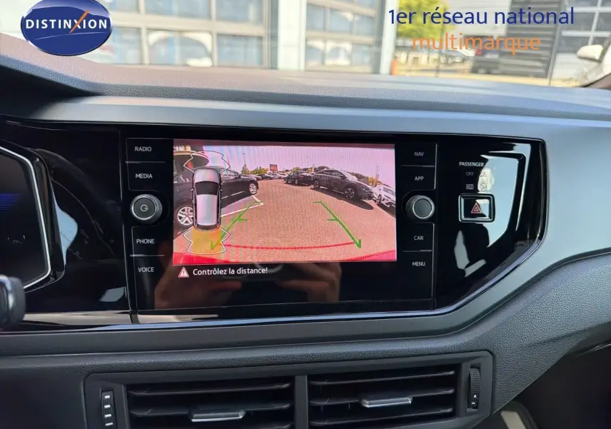 Vue rapprochée de l’écran multimédia intérieur affichant la caméra de recul d’une Volkswagen Polo rouge Roi 2023.