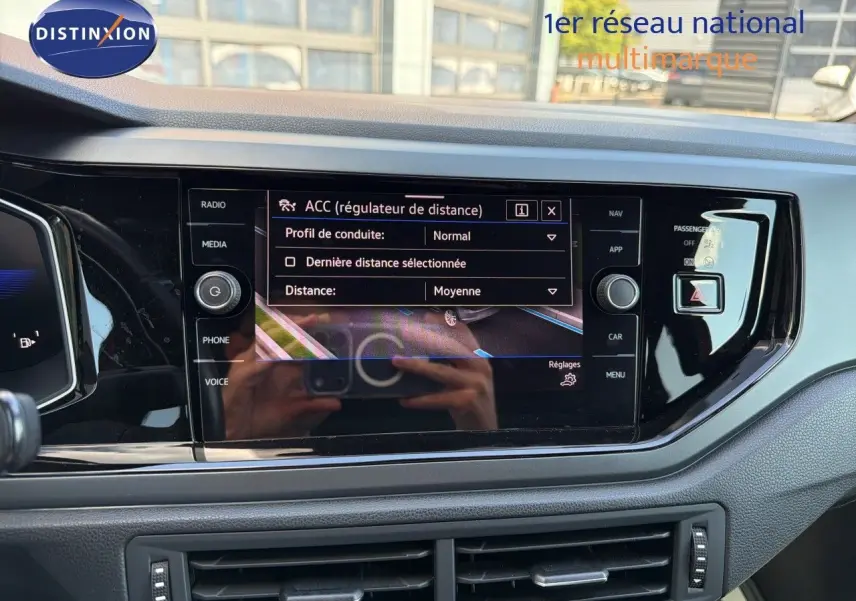 Vue rapprochée de l’écran tactile central noir brillant du tableau de bord d’une Volkswagen Polo rouge Roi 2023.