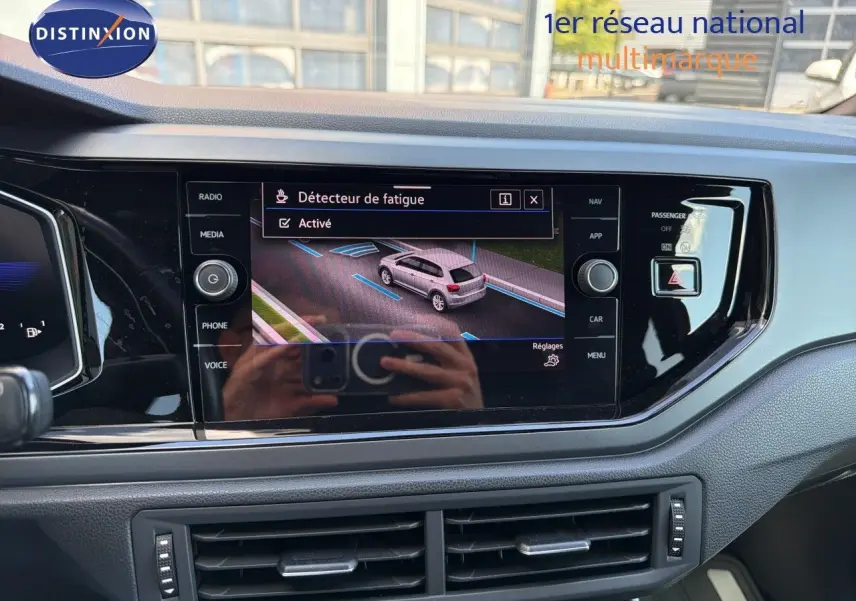 Vue rapprochée de l’écran tactile central du tableau de bord d’une Volkswagen Polo rouge Roi 2023 avec menu détecteur de fatigue activé.
