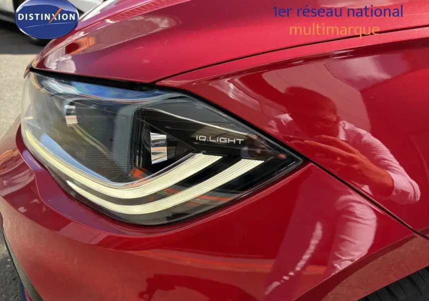 Gros plan sur le phare avant gauche d'une Volkswagen Polo rouge Roi 2023 avec éclairage IQ.Light.