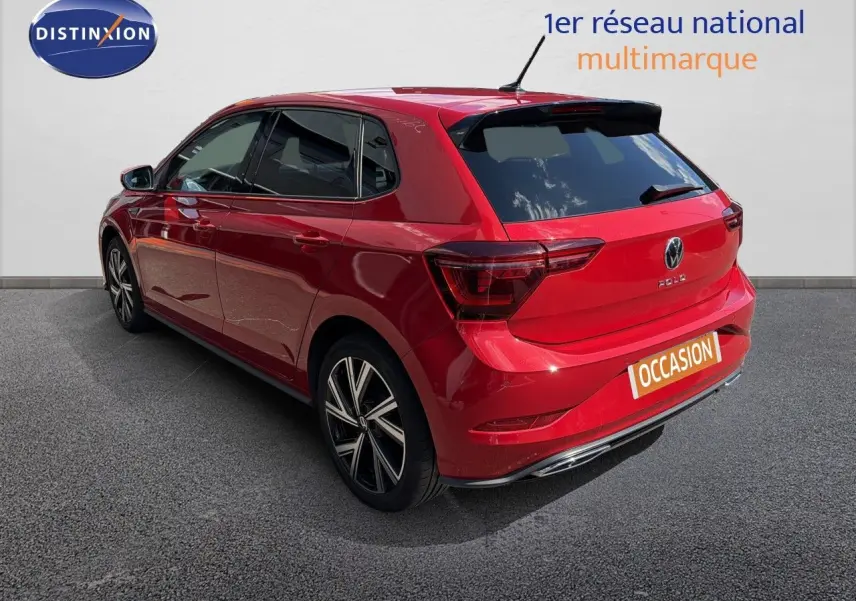 Vue 3/4 arrière droite d'une Volkswagen Polo rouge Roi 2023 finition R-Line avec jantes alliage et vitres teintées.