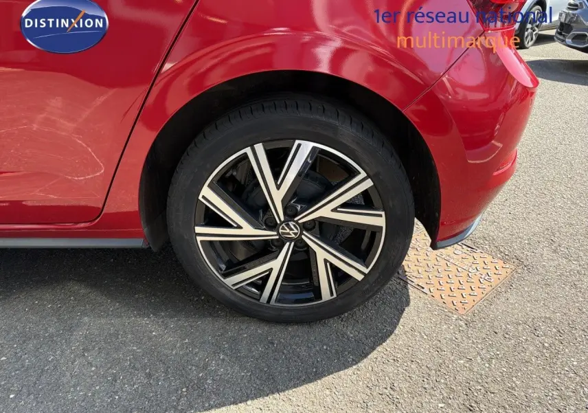 Gros plan sur la roue arrière droite d'une Volkswagen Polo rouge Roi 2023 avec jante alliage noire et argentée.