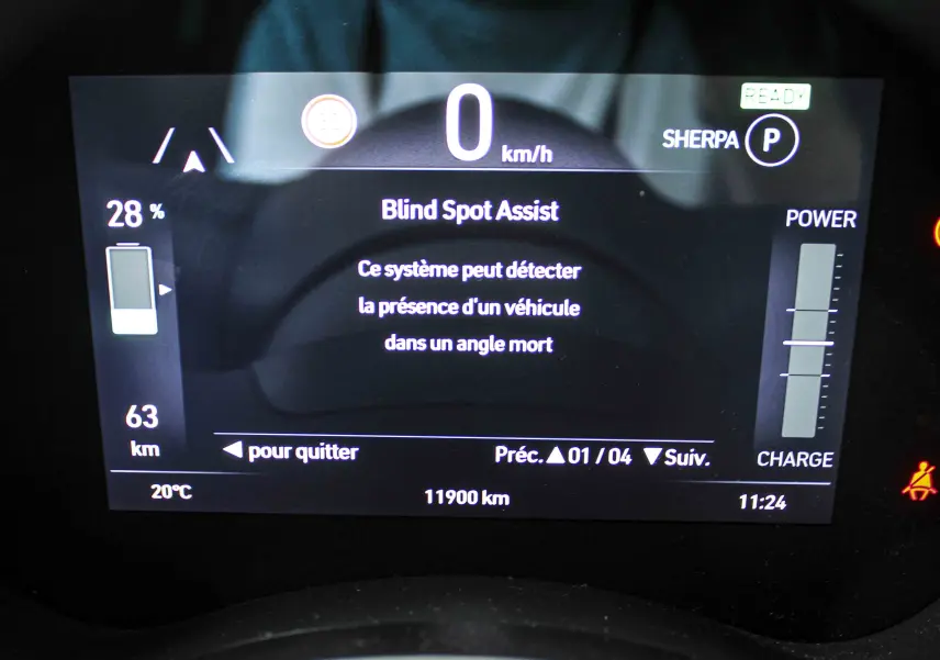 Écran numérique du tableau de bord de la Fiat 500 électrique affichant l'assistance angle mort et l'autonomie restante.