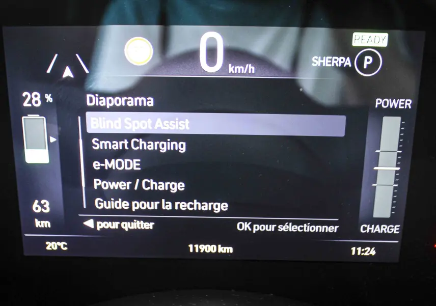 Tableau de bord numérique de la Fiat 500 électrique 2023 affichant l'assistance angle mort et l'autonomie restante.