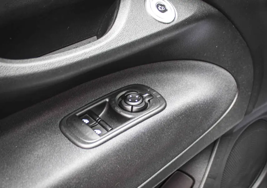Gros plan sur la commande de réglage des rétroviseurs et des vitres côté conducteur de la FIAT 500 électrique 2023, intérieur noir.