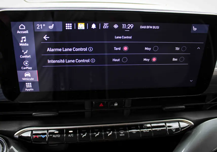 Écran tactile central de la Fiat 500 électrique 2023 montrant les réglages du Lane Control dans un intérieur noir.