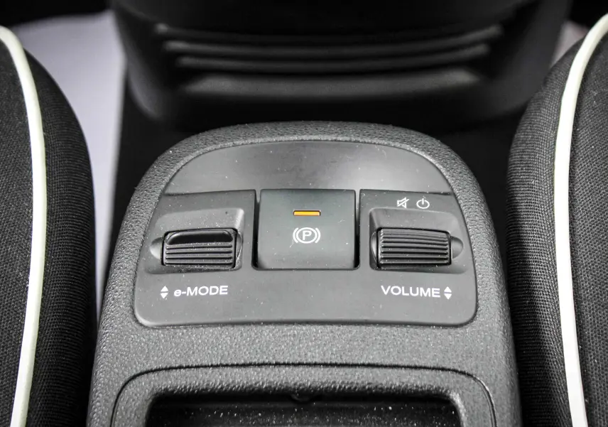 Vue rapprochée du panneau de commandes centrales avec réglages e-Mode et volume dans une Fiat 500 électrique gris minéral.