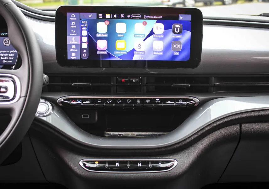 Vue intérieure du tableau de bord de la Fiat 500 électrique gris minéral, avec écran tactile central et commandes de climatisation.