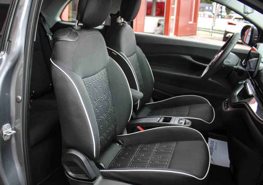 Vue intérieure côté gauche de la Fiat 500 électrique 2023 gris minéral, avec sièges tissu noir et surpiqûres blanches.