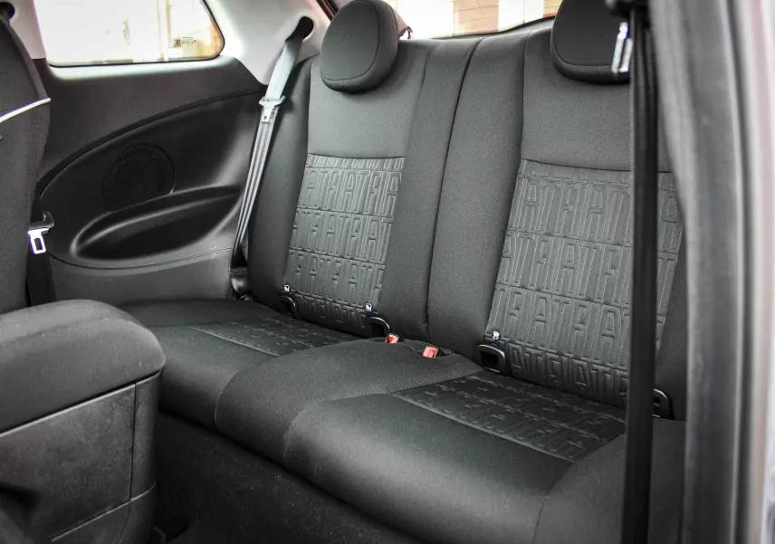 Vue intérieure arrière des sièges noirs avec motif FIAT embossé de la Fiat 500 électrique gris minéral 2023.