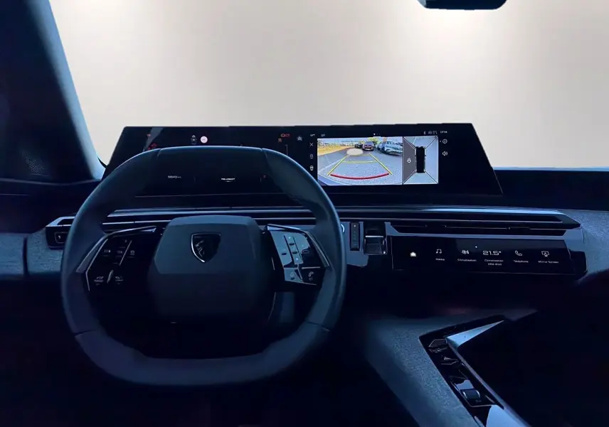 Vue intérieure du tableau de bord et volant cuir noir du Peugeot 5008 Hybrid 145 allure e-dcs6 avec écran tactile et affichage caméra de recul.