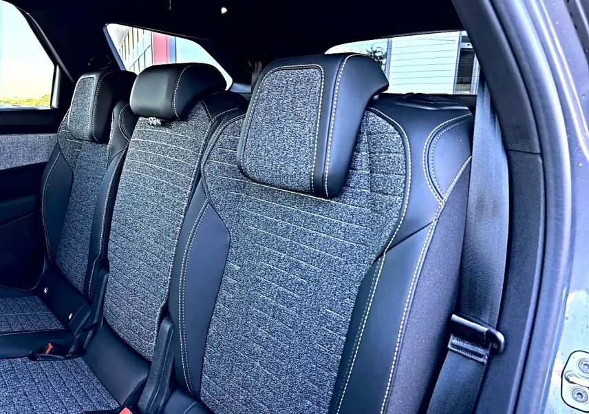 Vue intérieure des sièges arrière en tissu gris et cuir noir du Peugeot 5008 Hybrid 145 allure e-dcs6 2025.