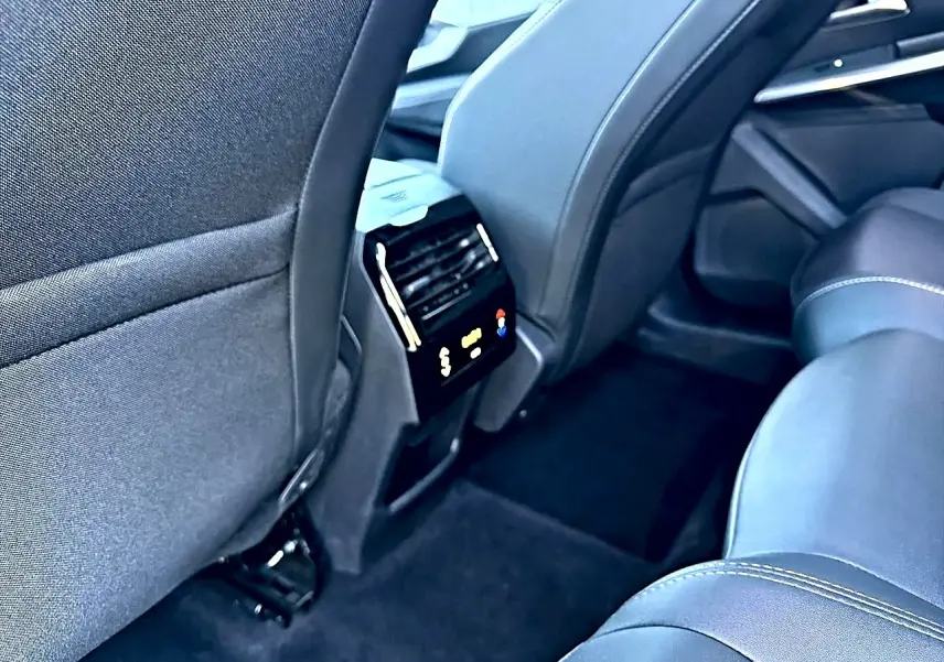 Vue arrière intérieure du Peugeot 5008 gris artense, mettant en valeur la climatisation tri-zone et les sièges en tissu.