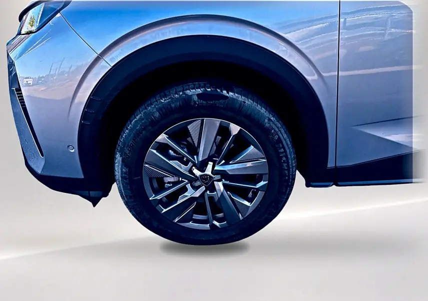 Gros plan sur la roue avant droite et l'aile gris artense du Peugeot 5008 Hybrid 145 allure e-dcs6 2025.