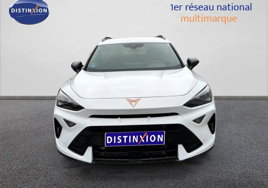 Vue frontale d'un CUPRA Formentor blanc neige métal avec calandre noire et logo cuivré bien visible.