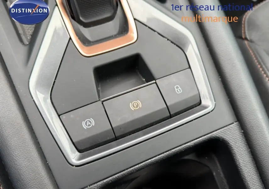 Gros plan sur la console centrale du CUPRA Formentor 1.5 eTSI 150CH DSG7, montrant les boutons de frein à main et verrouillage.