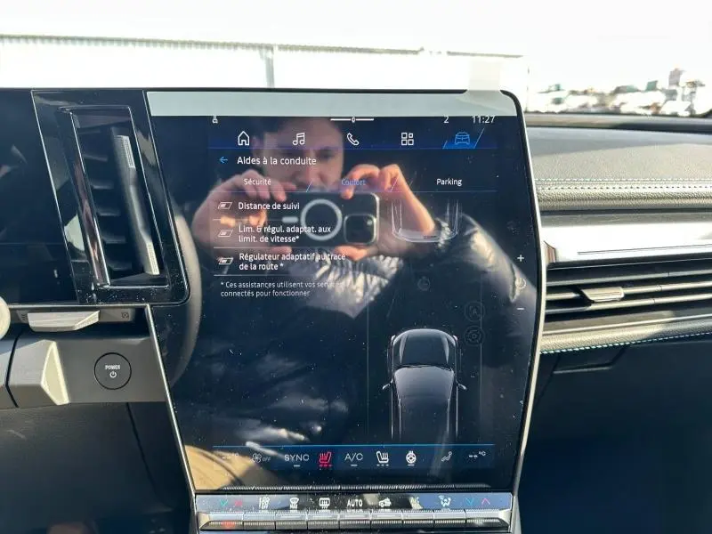 Écran tactile central du tableau de bord du Renault Scenic E-Tech gris, affichant les réglages d’aide à la conduite.