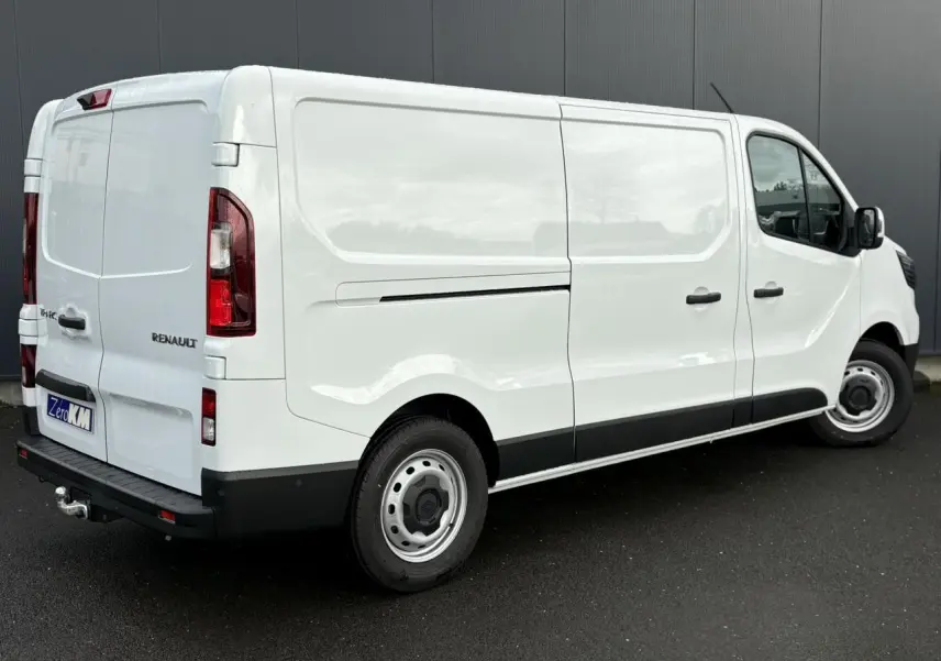 Vue 3/4 arrière droite du Renault Trafic Fourgon blanc Glacier avec attelage et porte latérale coulissante.