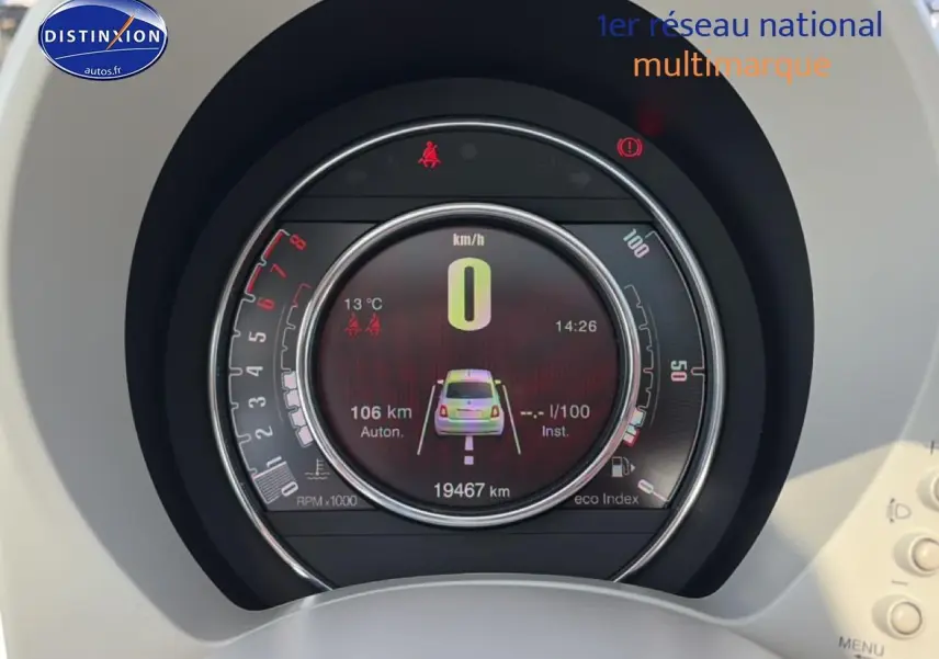 Vue rapprochée du tableau de bord numérique du Fiat 500 blanc, affichant le compteur et les alertes de sécurité.