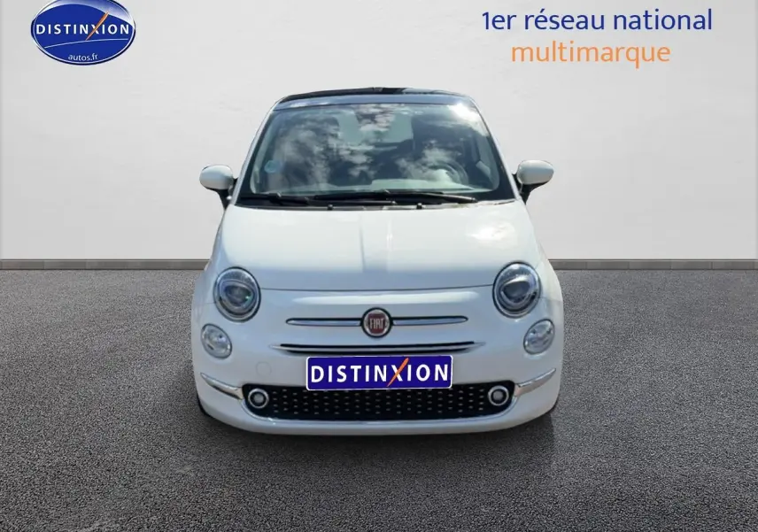 Vue avant d'une Fiat 500 blanche 2023 avec toit panoramique et phares ronds caractéristiques.