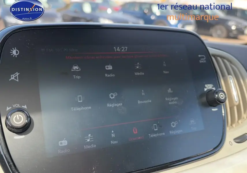 Écran tactile central de la Fiat 500 blanc, affichant le menu multimédia avec commandes autour, vue intérieure rapprochée.