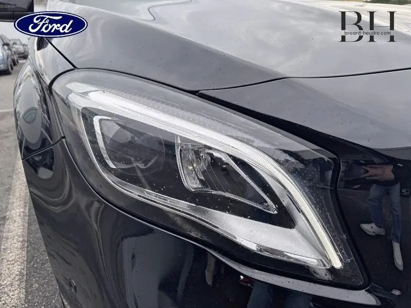 Gros plan sur le phare avant droit noir cosmos du Mercedes GLA 180 d Fascination 2018 avec éclairage LED distinctif.