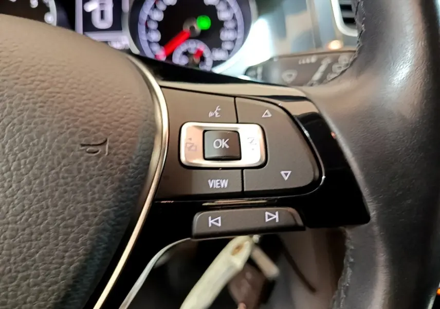 Gros plan sur le volant cuir noir multifonctions de la Volkswagen Golf 1.0 TSI 115 DSG7 Connect, avec commandes intégrées.