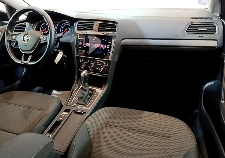 Vue intérieure avant droite de la Volkswagen Golf noire 2019, avec tableau de bord moderne et volant cuir multifonctions.