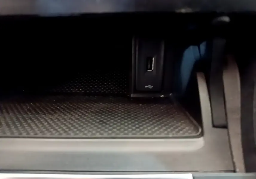 Gros plan sur la prise USB dans le compartiment de rangement intérieur de la Volkswagen Golf noire.